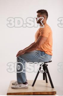 Sitting pose orange thsirt light blue jeans of bodybuilder Harold…